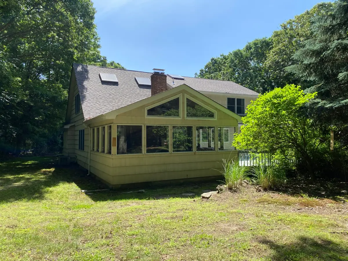 Trying to stop a foreclosure in Smithtown: glassed sunroom on the back of a Cape