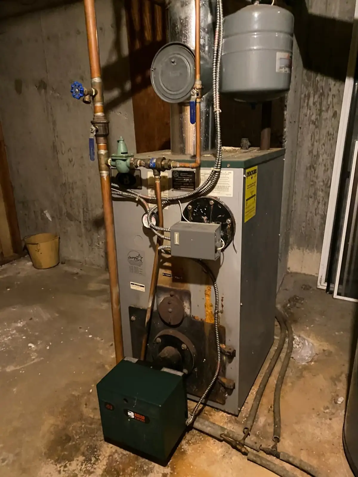 Selling a house with a reverse mortgage in Smithtown: old oil burner on a stained concrete floor