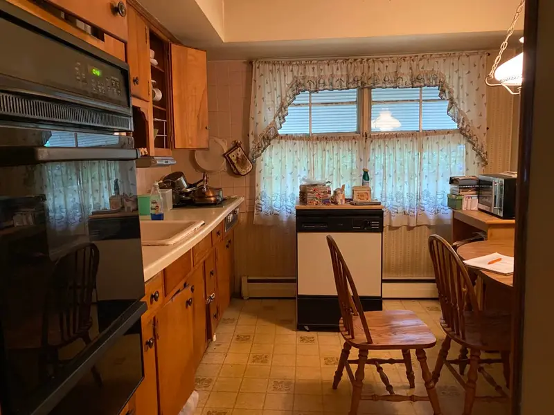 Original wood kitchen with wall oven and lace curtains, Smithtown, NY